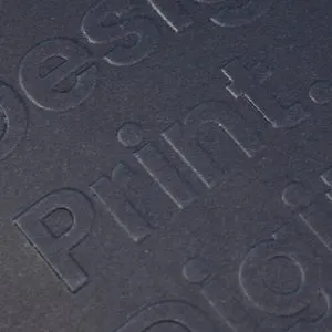 Close-up van in reliëf aangebrachte tekst op donker gestructureerd papier door KanzoPack.