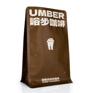 Una bolsa de fondo plano de café marrón de KanzoPack con la marca Umber y un icono de una taza de café.